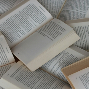 Livres ouverts en plan oblique, pages crème et texture papier, ambiance lecture et bibliothèque.