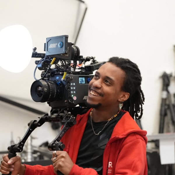 Opérateur souriant avec caméra ARRI et stabilisateur en studio.