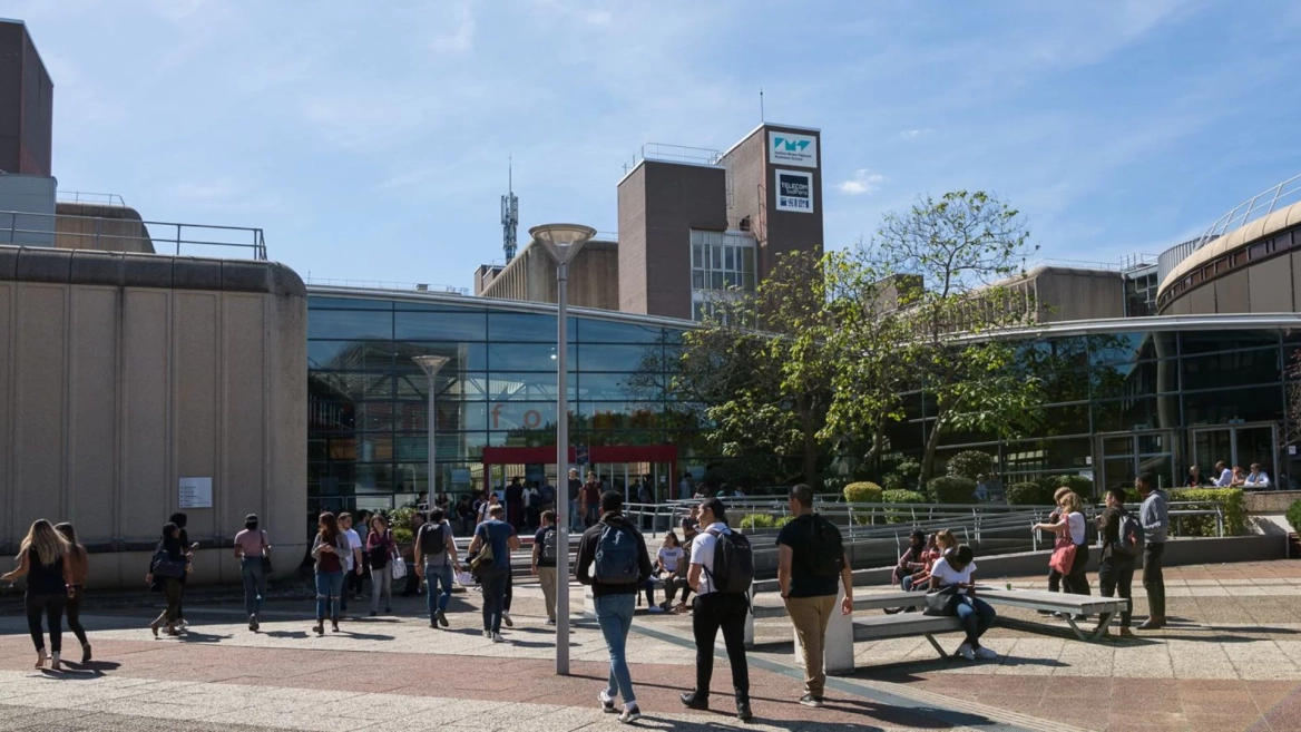Place devant IMT-BS : étudiants sur le campus, façade vitrée et volumes en béton.