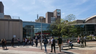Place devant IMT-BS : étudiants sur le campus, façade vitrée et volumes en béton.