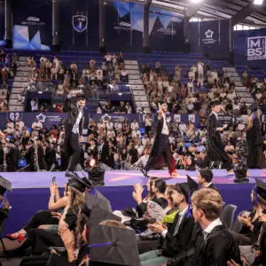 Remise des diplômes MBS Montpellier : cérémonie étudiante sur scène avec toges et diplômés.