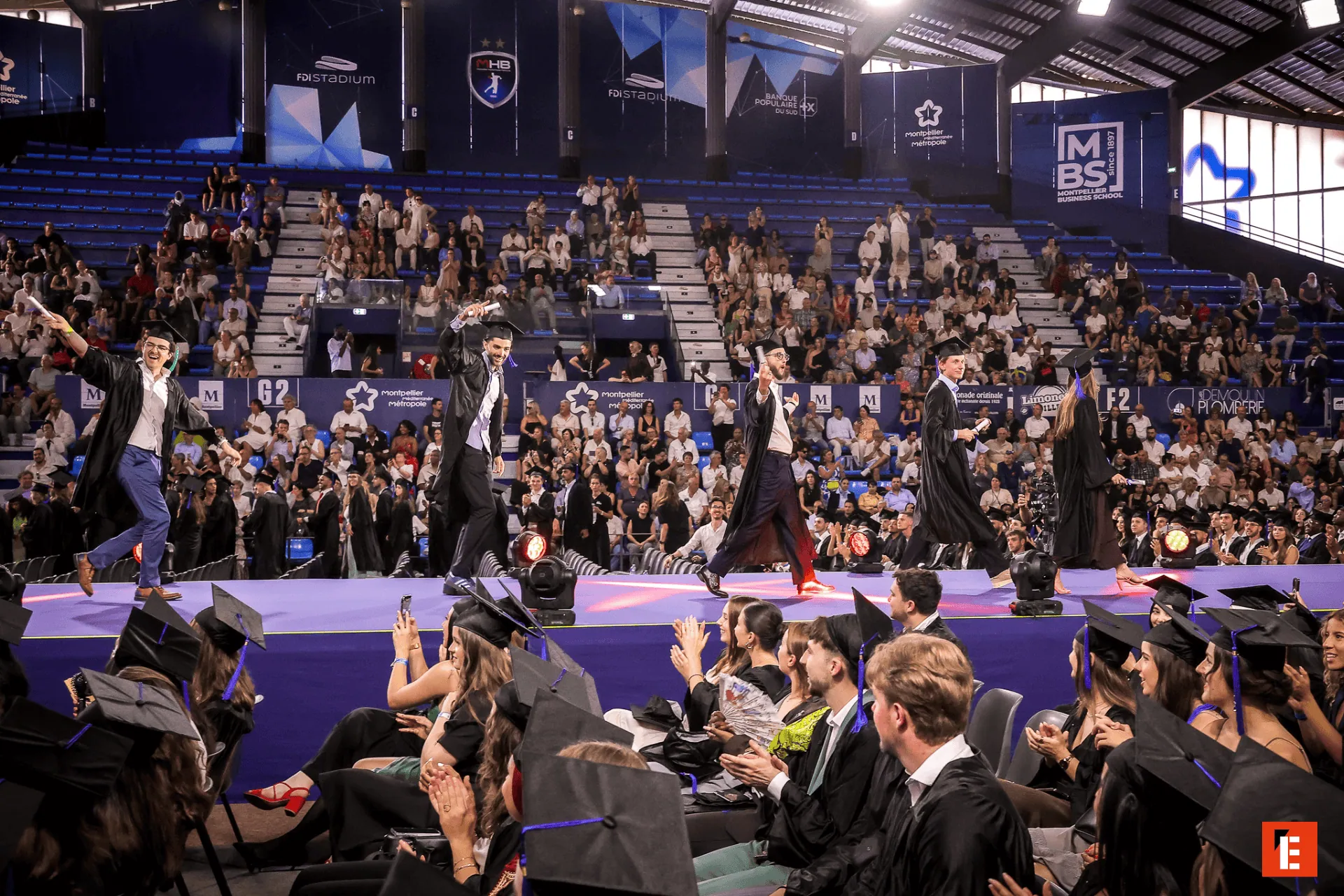 Remise des diplômes MBS Montpellier : cérémonie étudiante sur scène avec toges et diplômés.