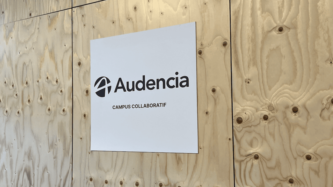Panneau blanc Audencia avec logo et mention « Campus collaboratif » sur bois brut.