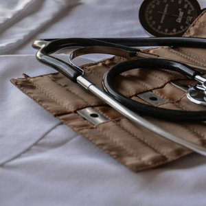 Stéthoscope et tensiomètre sur tissu blanc, instruments médicaux de clinique et brassard.