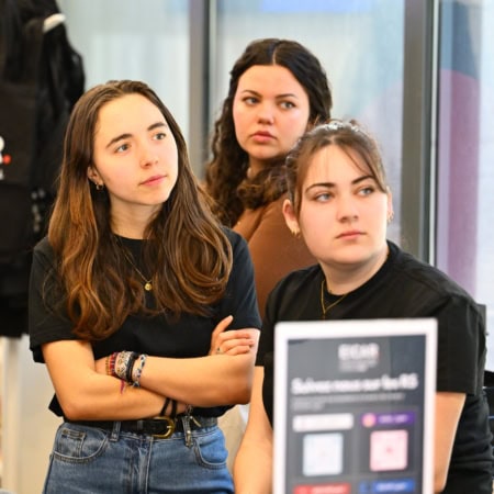 Trois jeunes étudiants attentifs lors dun atelier en intérieur.