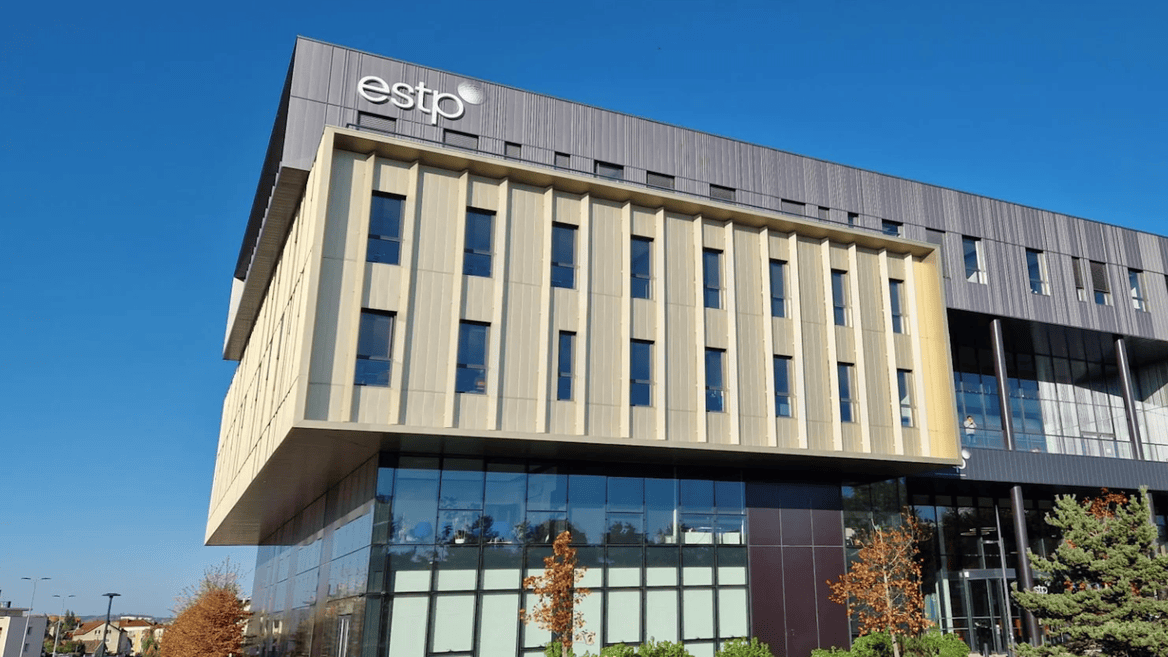 Bâtiment contemporain ESTP en verre et métal, façade surplombante, fenêtres verticales, ciel bleu.