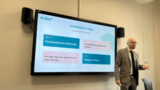 Présentation Momentum 2030 esdes Business School : intervenant devant écran affichant 4 axes stratégiques.