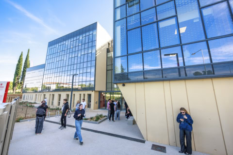 Campus ESSCA Aix, façade vitrée moderne, étudiants dans la cour.