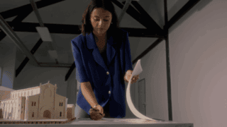 Une femme feuillette un plan.